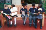 Children reading on bench Children reading on bench